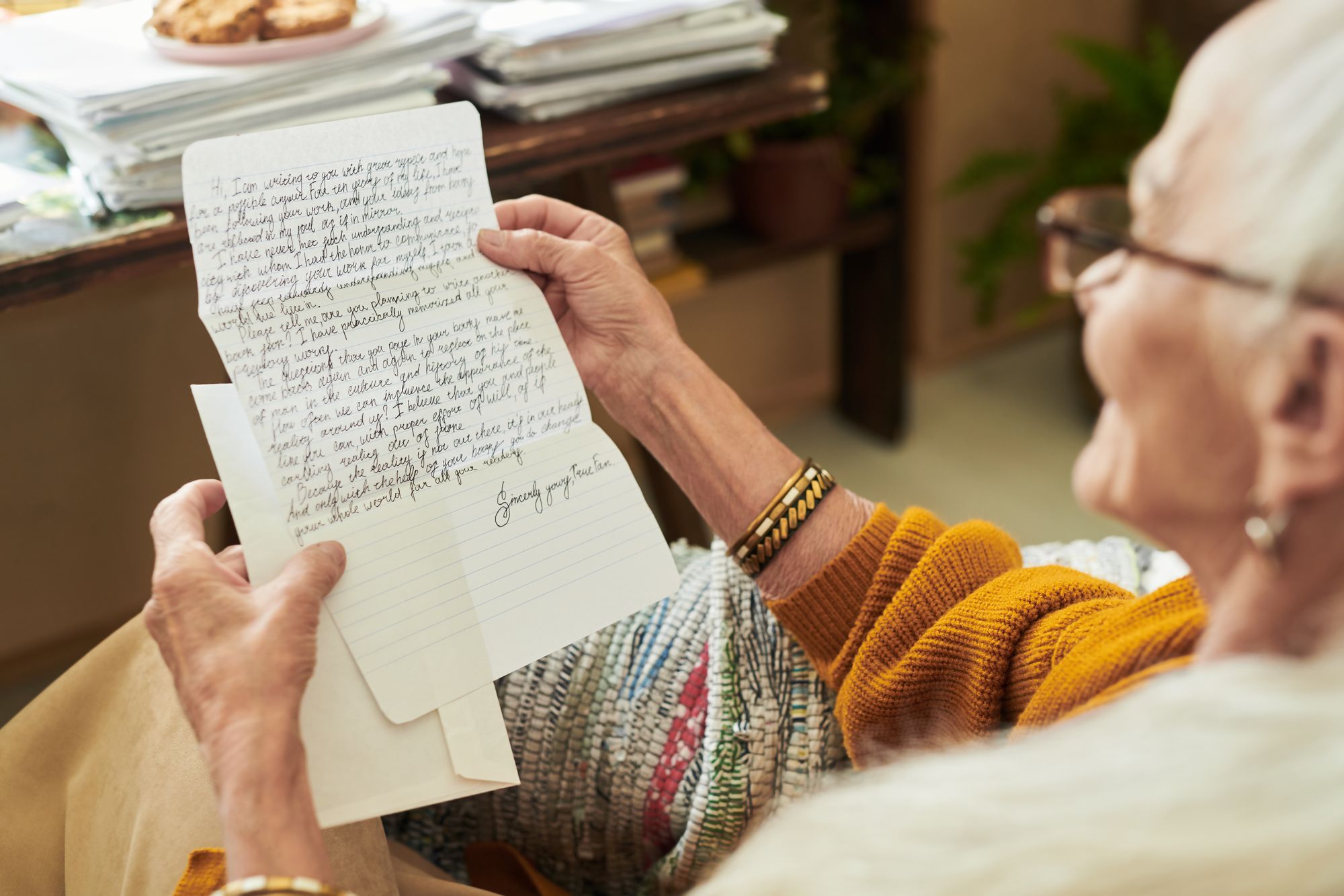 grand mère qui lit une lettre manuscrite reçue avec un cadeau