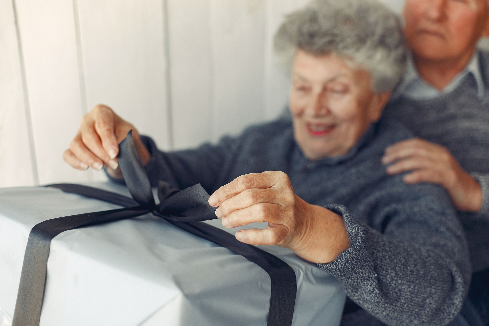 ouverture d'un cadeau par une grand-mère et un grand-père